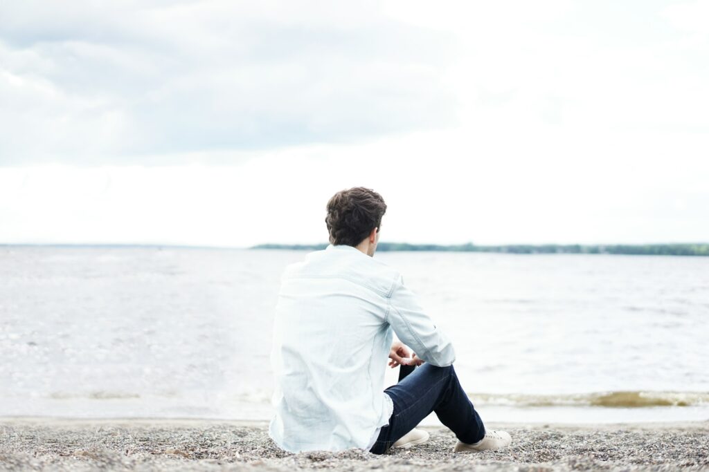 man on the beach looking out at the water